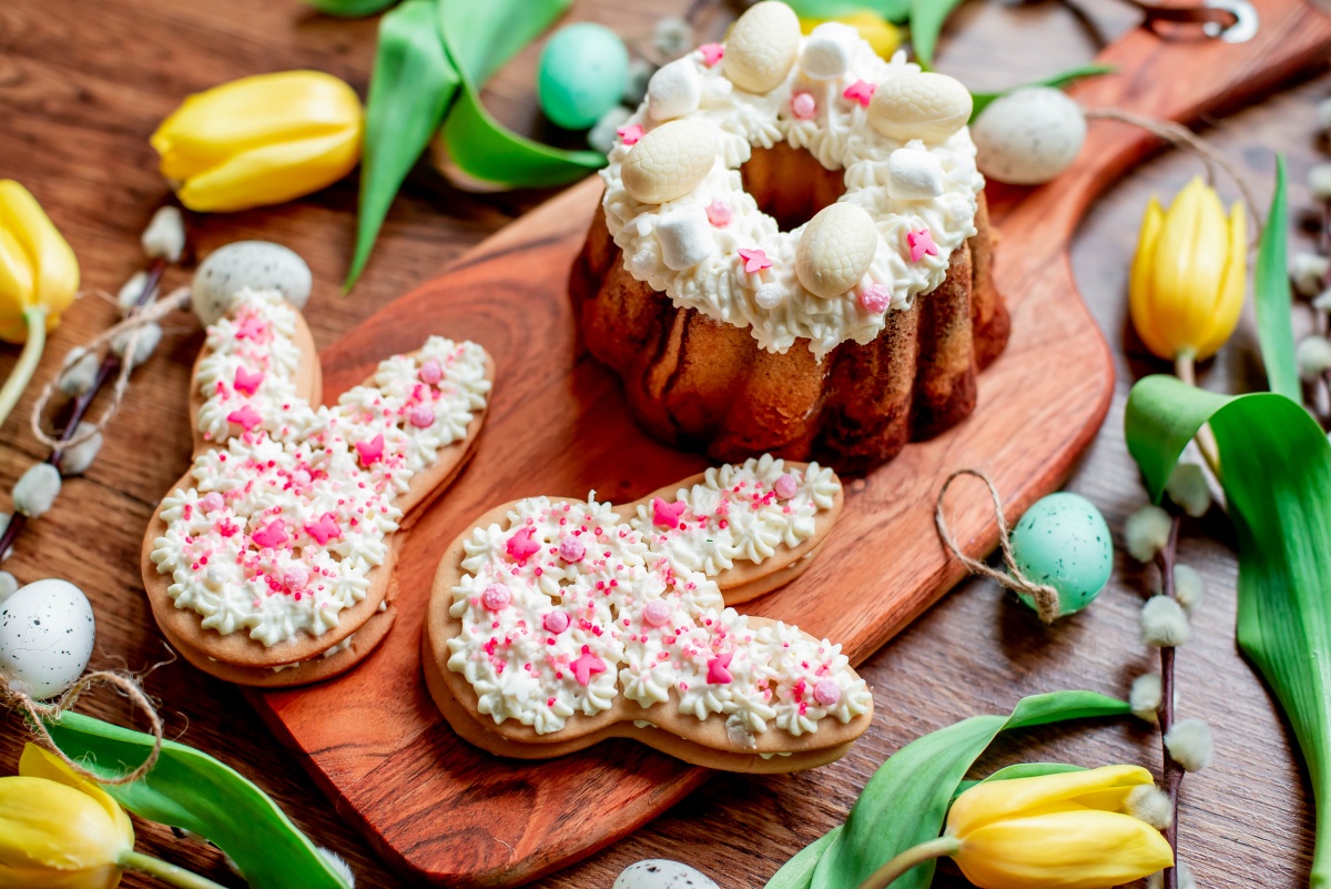 Zdobione ciastka w kształcie króliczków obok baby wielkanocnej